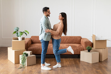 Fototapeta na wymiar Happy man and woman hugging in their new flat
