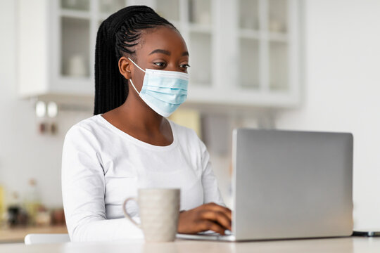 Portrait Of Black Woman In Mask Working On Computer