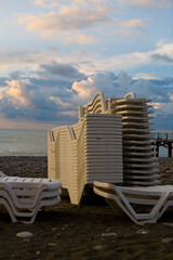 The sun loungers are stacked on the seashore.