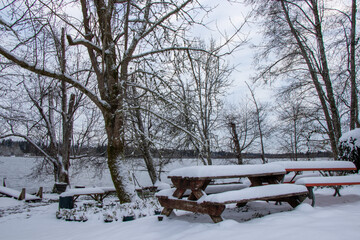 Northwest Lake benches covered in snow after winter storm.