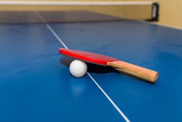 Dusty Paddle, tennis ball on blue ping pong table close up.Blue table tennis or ping pong.Selective...