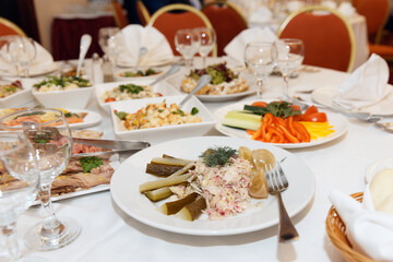 Set table with pickles, meats, fish and salads