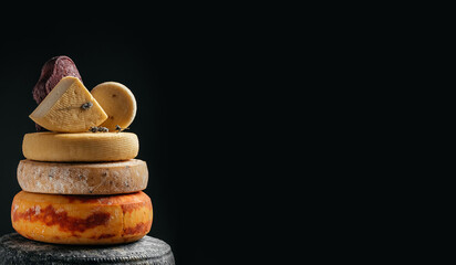 Various kind of cheese. head of handcrafted hard cheese on a dark background