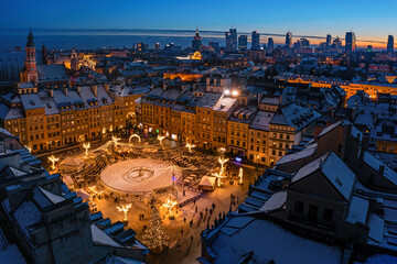 Warszawa, rynek starego miasta udekorowany świątecznym oświetleniem, widok z lotu ptaka na ośnieżone budynki i centrum miasta w oddali - obrazy, fototapety, plakaty