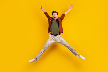 Fototapeta na wymiar Full body photo of young excited guy have fun jump up energetic free-time isolated over yellow color background