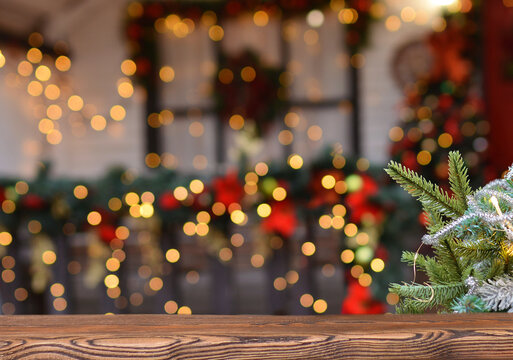Christmas background. Empty wooden board on background of blurred christmas house outdoors and New Year's golden bokeh.Ready for product montage. Banner. Copy space