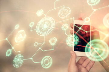 Double exposure of social network sketch hologram and woman holding and using a mobile device.