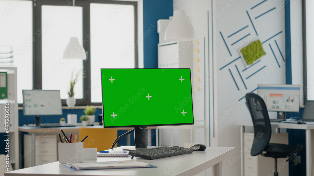Poster close up of empty desk with isolated green screen on monitor. computer with chroma key and mock up t