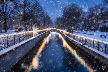 Fototapeta premium Christmas lights over the Radunia canal in Pruszcz Gdanski at dusk, Poland.