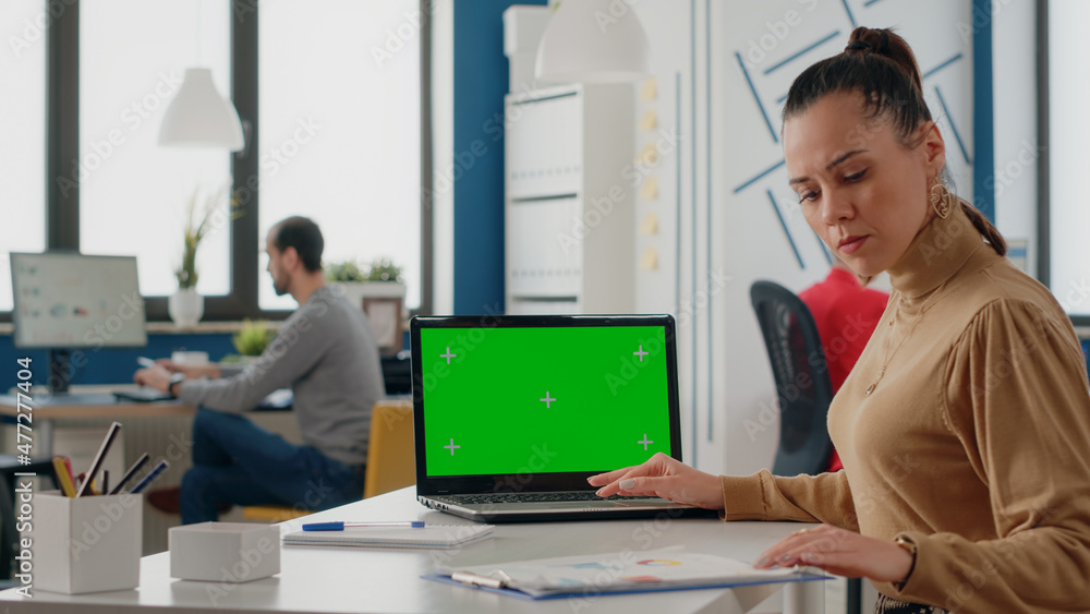 Poster person working with green screen on laptop in business office. woman employee using computer with is