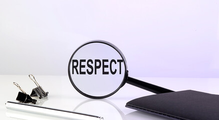 RESPECT text concept. Magnifier glass with text with notebook and pen,business