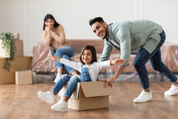 Happy middle eastern family celebrating moving day in new apartment