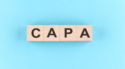 Wooden cube block with text CAPA on the blue background
