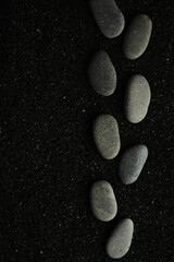small sea pebbles are laid out on a black background