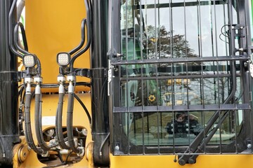 Gelber Bagger mit Fensterfront und Kran 