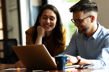 Colleagues in office. Businesswoman and businessman discussing work in office. Two friends working together.