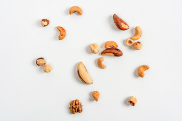 Different nuts are scattered on a white background. Walnuts, hazelnuts and Brazil nuts. The concept of healthy eating and snacking