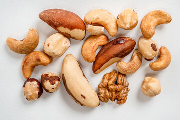 Different nuts are scattered on a white background. Walnuts, hazelnuts and Brazil nuts. The concept of healthy eating and snacking