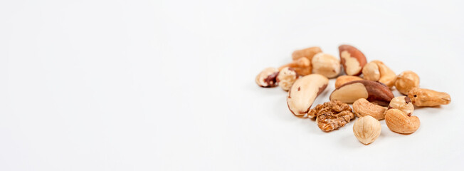 Different nuts are scattered on a white background. Walnuts, hazelnuts and Brazil nuts. The concept of healthy eating and snacking