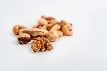 Different nuts are scattered on a white background. Walnuts, hazelnuts and Brazil nuts. The concept of healthy eating and snacking