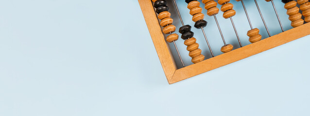 Wooden old abacus on a blue background. Flat lay and top view. Business or accounting concept - obrazy, fototapety, plakaty