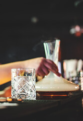man hand bartender making cocktail in bar with smoke