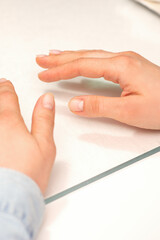 Hands of a young woman with well-groomed nails on the manicure table