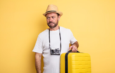 middle age man tourist feeling sad, upset or angry and looking to the side. travel concept