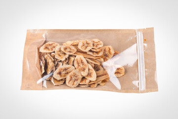 Banana fripses. Dried banan packaged on a white background, vegan snack.