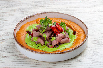Hummus with veal sous-vide and parsley cream.