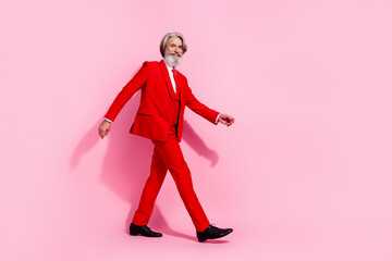 Fototapeta na wymiar Full length profile portrait of neat dandy aged person walking have good mood isolated on pink color background