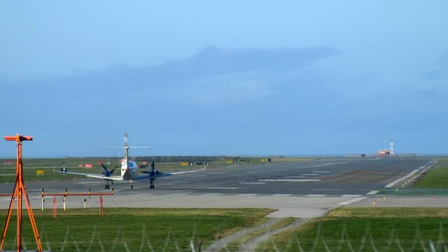 Turboprop Aircraft Rolling Down the Runway and Taking Off, Rear Static