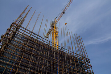 Reinforced concrete structure and tower crane against the blue sky. Foundation construction. Construction site concrete structure.