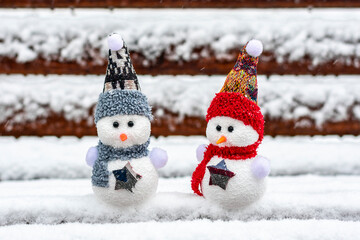 Merry christmas and happy new year greeting card with copy space Happy two little snowmen in red, blue cap and scarf standing in winter snow background Xmas fairytale Hello January, February concept
