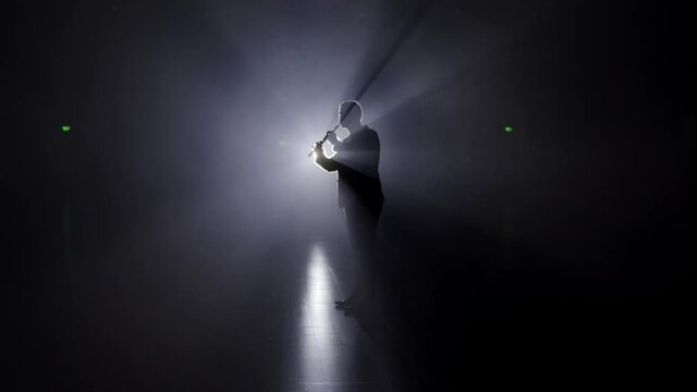 Person is playing the duduk, flute on black background 4K. Man playing classical music in the dark on a stage