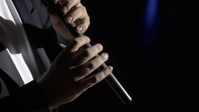 Close up hands playing the duduk on black background 4K. Man playing classical music