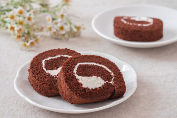 Chocolate roll cake on white plate