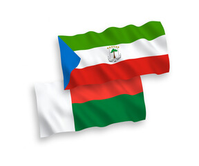 National vector fabric wave flags of Republic of Equatorial Guinea and Madagascar isolated on white background. 1 to 2 proportion.