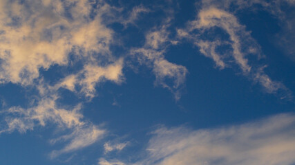 Ciel orangé en fin de soirée, sous des passages nuageux de haute altitude