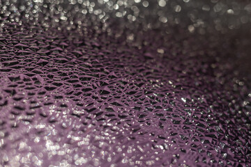 Abstract background of glass transparent texture. Bright shiny backdrop. Defocused. Blurred bokeh. Party, holiday and festive concept. Blurred background. Selective focus.