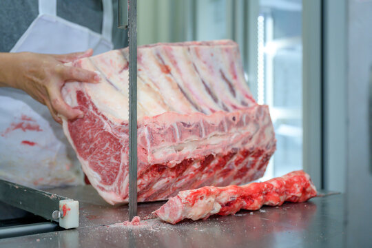 Close-up of raw meat cutting with a saw or bone cutter in an abattoir where wagyu is cut and trimmed in the meat industry. Sliced wagyu beef at beef cattle restaurants in various parts of Japan