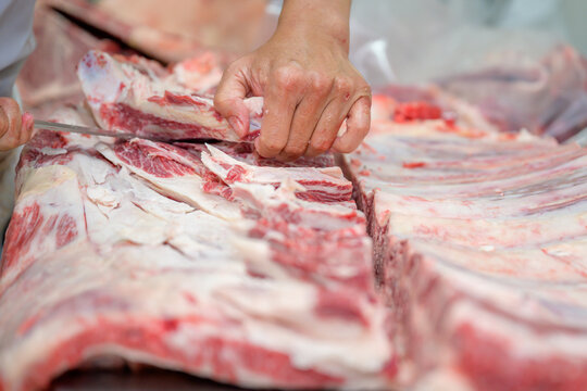 Close-up of raw meat cutting with a knife in an abattoir doing butchering and trimming of wagyu beef in the meat industry. Wagyu beef slices in beef cattle restaurants in many parts of Japan.