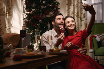 Happy couple taking christmas selfie at home