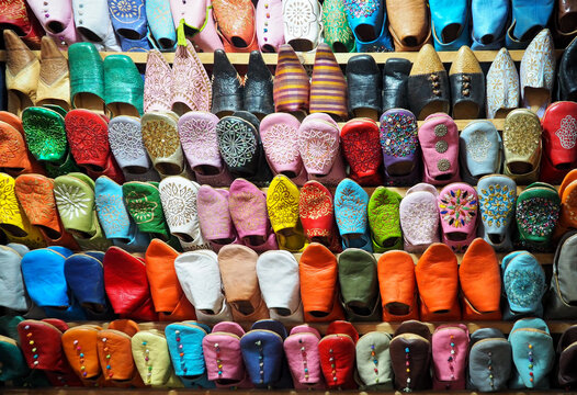 Handmade colourful babouche - leather slippers on display at traditional souk - street market in Morocco
