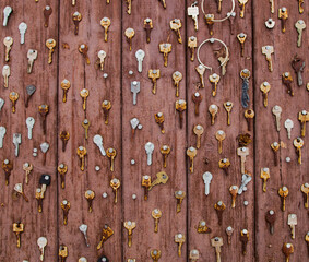 Rusty metal keys on a painted brown wooden plank. A concept background texture photo