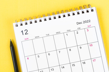 December 2022 desk calendar on yellow background.