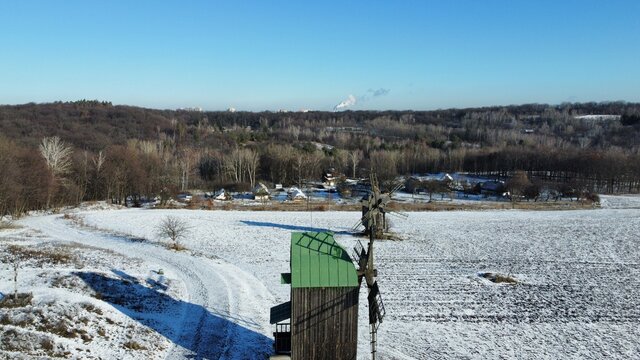 Old abandoned windmills in a snowy field.  Pyrohiv museum Kyiv, Ukraine