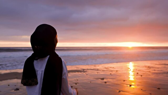 Somali-American woman watching the sunset at a beach in Malibut.