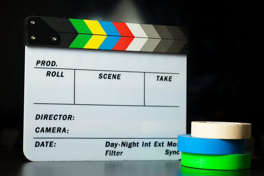 Film clapper board with colored marking tapes in internet content producer dark background studio. Clapperboard concept. content producer concept.
