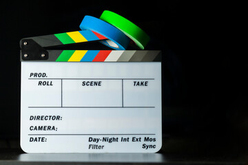 Film clapper board with colored marking tapes in internet content producer dark background studio. Clapperboard concept. content producer concept.
